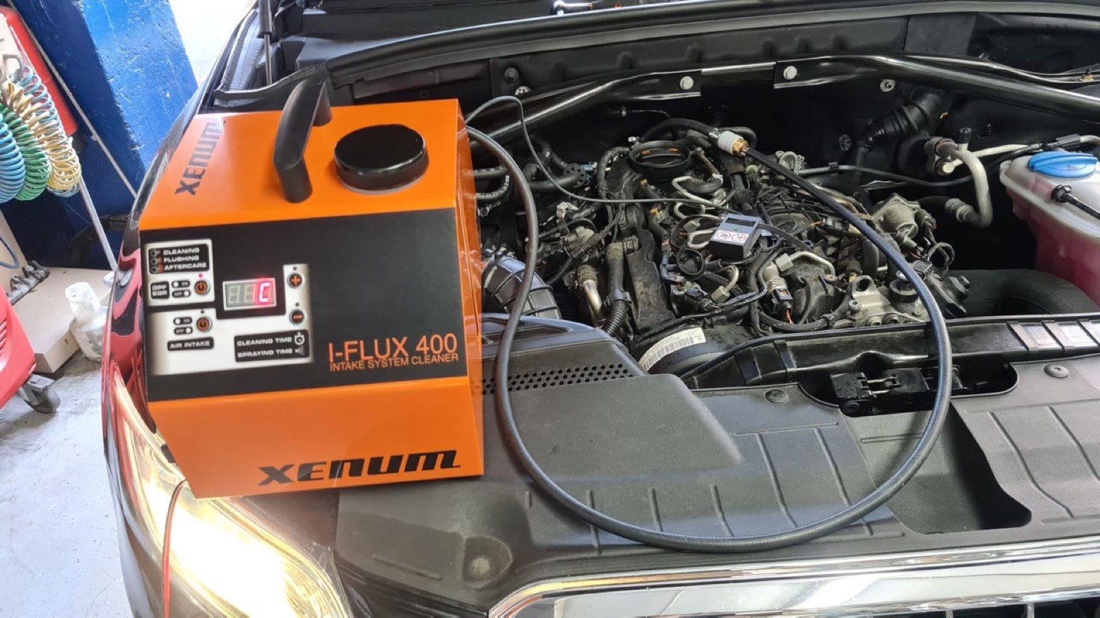 Equipo profesional conectado al motor de un vehículo en el taller