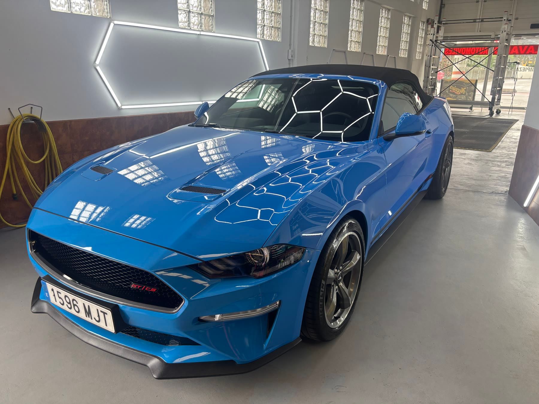 Ford Mustang descapotable azul en la zona de detailing de Garage Rodríguez